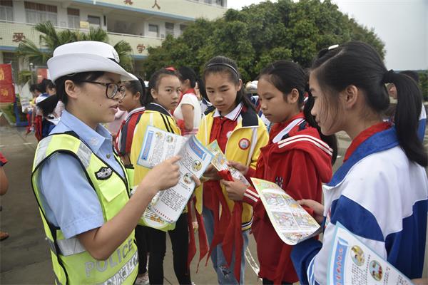 民警给小学生送上学校交通安全常识宣传单.jpg