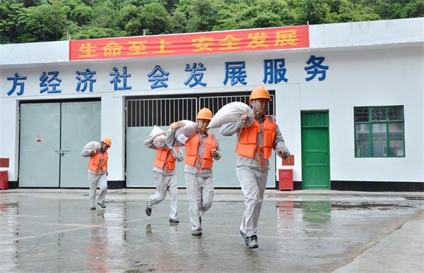 为防止厂房进水,现场演练人员扛沙袋对厂房门口进行封堵..jpg