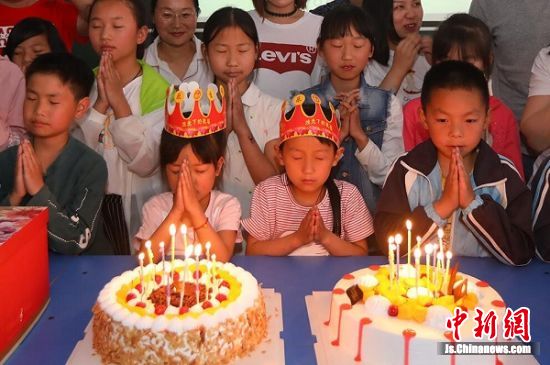 在该校“益心华泰·关爱儿童之家”,志愿者们陪同孩子们一起过集体生日。中新社记者 泱波 摄