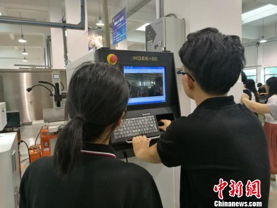 学员在教师的指导下熟悉各种机械的操作方式。 钟升 摄