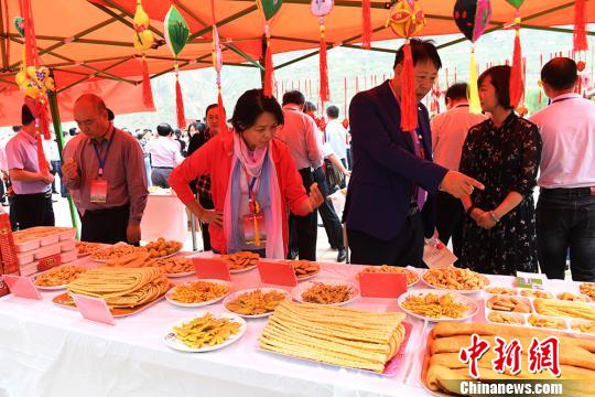 图为马娟(右二)给考察项目团人员推荐花馃馃。 杨艳敏 摄