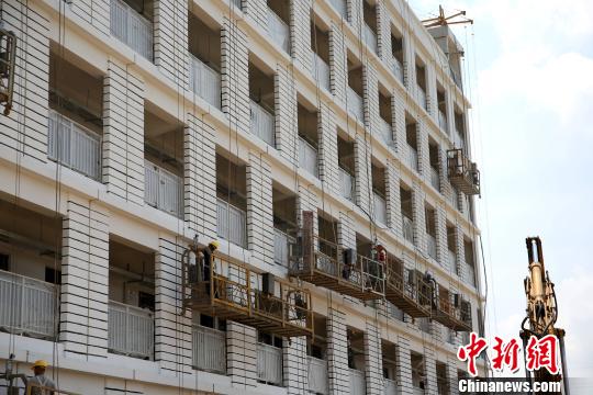 使用新型墙材——轻质隔墙板的装配式建筑，工人正在装修外墙。　朱柳融 摄