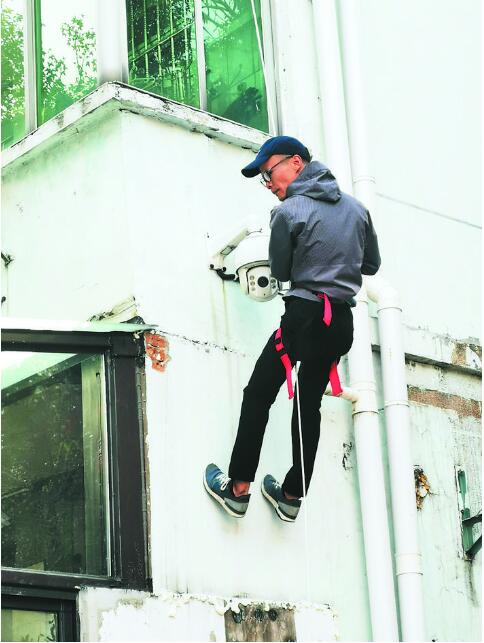 工作人员正演示如何使用缓降绳逃生。